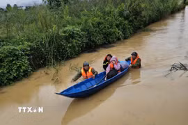Lực lượng chức năng đưa người dân bị mắc kẹt do ngập sâu tại phường 3 Bảo Lộc (Lâm Đồng) đến nơi an toàn. (Ảnh: TTXVN phát)