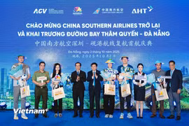 Những du khách đầu tiên từ Thâm Quyến (Trung Quốc) đến Đà Nẵng được chào đón và tặng quà lưu niệm. (Ảnh: PV/Vietnam+)