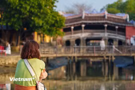 Một du khách tận hưởng không gian Chùa Cầu (Phố cổ Hội An) lúc sáng sớm. (Ảnh: Thanh Phong/Vietnam+)