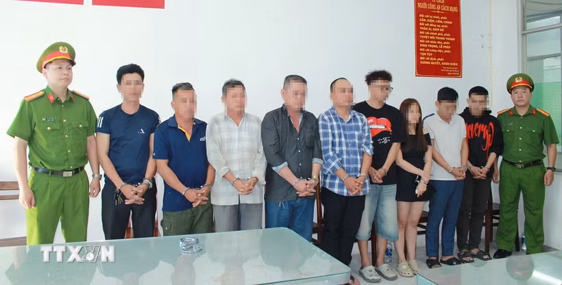 Nhóm 9 người liên quan trong vụ khiêng “quan tài” diễu phố tại Cơ quan điều tra. (Ảnh: TTXVN phát)