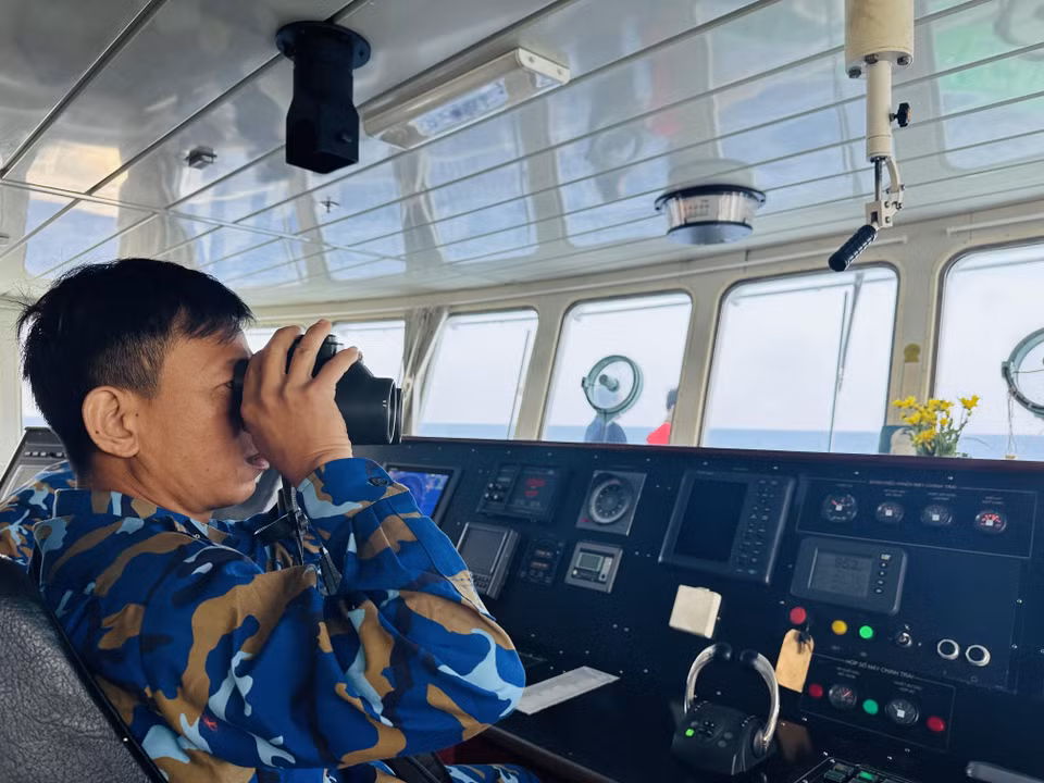 Thuỷ thủ trưởng Tàu 571 Nguyễn Sỹ Hà quan sát bằng ống nhòm khi có một tàu phía trước sắp đi ngang qua. (Ảnh: Thùy Giang/Vietnam+)