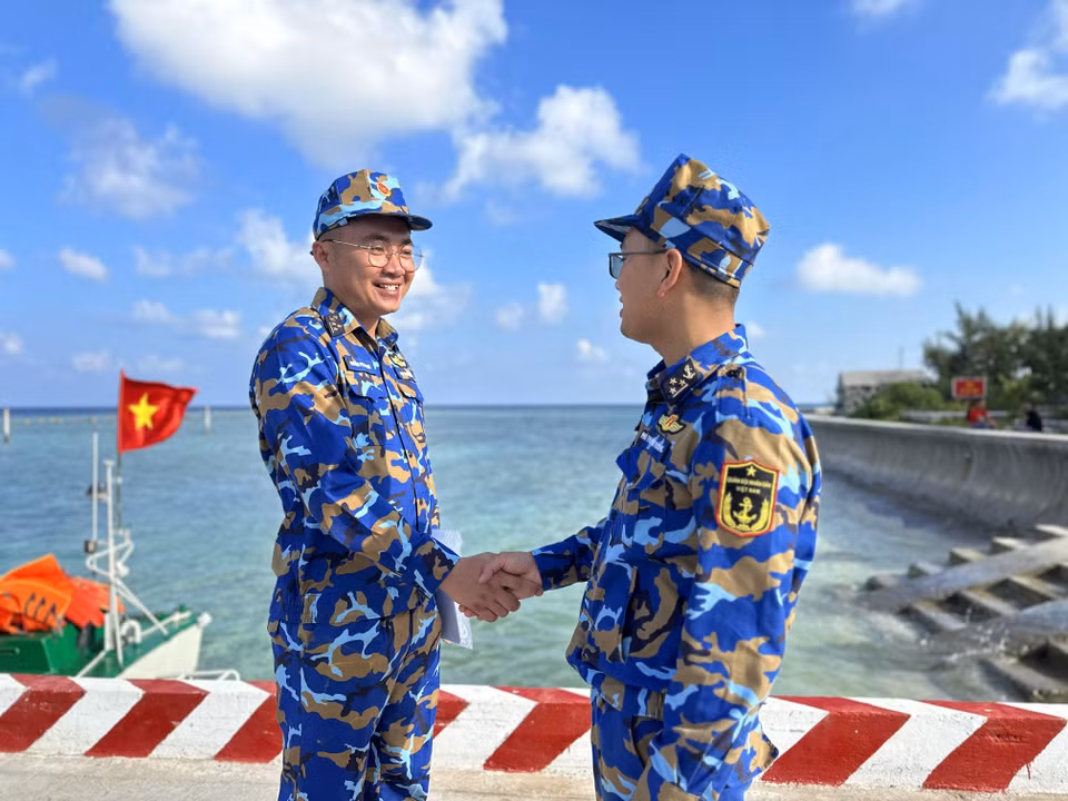 Phó Thuyền trưởng Tàu 571 Trần Ngọc Sáng chia sẻ kinh nghiệm với Phó Thuyền trưởng Nguyên Phi Hoàng của tàu Trường Sa 20 đang làm nhiệm vụ trên biển khu vực đảo Trường Sa. (Ảnh: Thùy Giang/Vietnam+)