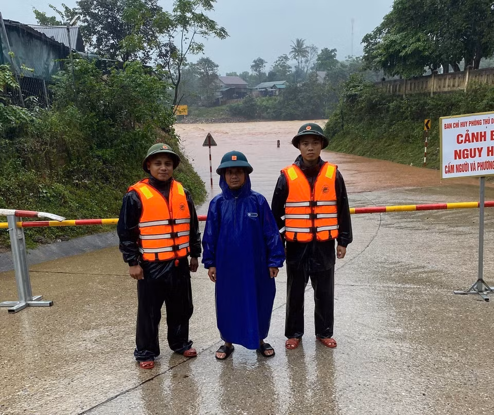 Các lực lượng chức năng lập barie canh gác không cho người và phương tiện qua lại nơi bị ngập sâu. (Ảnh: TTXVN phát)