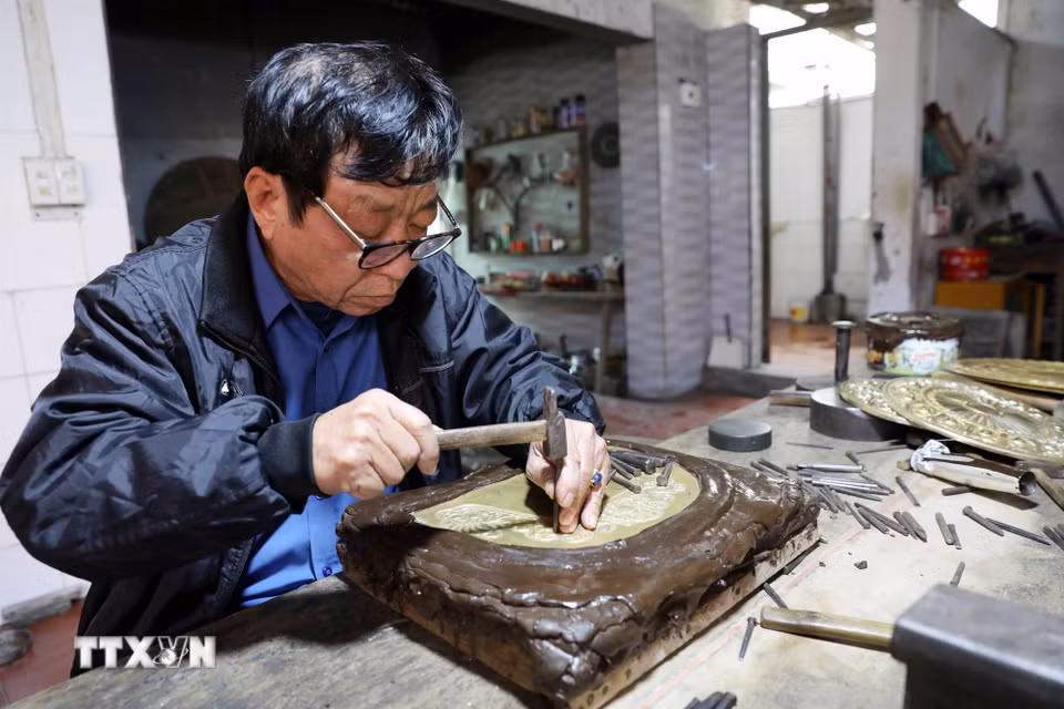 Nghệ nhân Đinh Quang Thắng (66 tuổi, thôn Nam Hòa, xã Hồng Thái) khắc chạm thủ công bằng kỹ thuật tinh xảo. (Ảnh: Thế Duyệt/TTXVN)