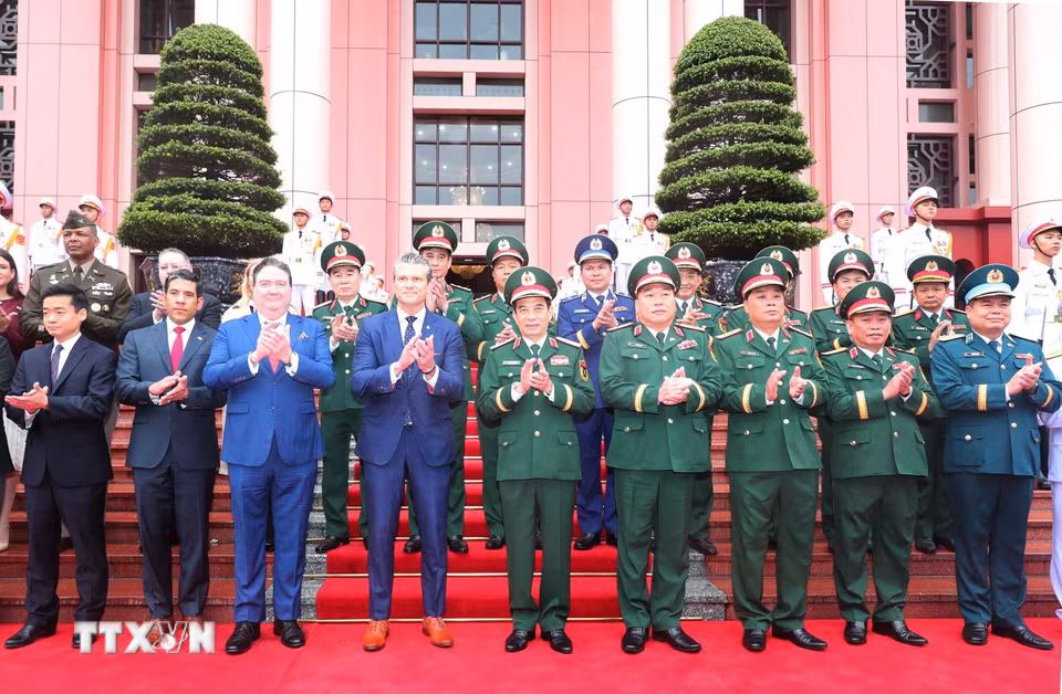 Đại tướng, Bộ trưởng Quốc phòng Phan Văn Giang và Bộ trưởng Chiến tranh Hoa Kỳ Pete Hegseth cùng các thành viên hai đoàn chụp ảnh chung. (Ảnh: Trọng Đức/TTXVN)
