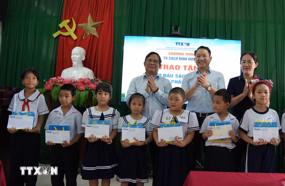 Lãnh đạo Trung tâm Thông tin TTXVN khu vực miền Trung-Tây Nguyên cùng các đại biểu trao tặng 20 suất học bổng cho học sinh có hoàn cảnh khó khăn của trường Tiểu học Tây Nha Trang. (Ảnh: Nguyễn Dũng/TTXVN)