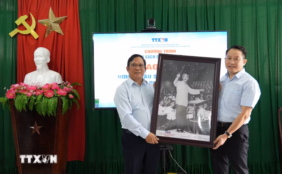 Ông Nguyễn Việt Dũng (phải), Bí thư Đảng ủy, Giám đốc Trung tâm Thông tin TTXVN khu vực miền Trung-Tây Nguyên, trao tặng bức ảnh Bác Hồ cho lãnh đạo Trường Tiểu học Tây Nha Trang. (Ảnh: Nguyễn Dũng/TTXVN)