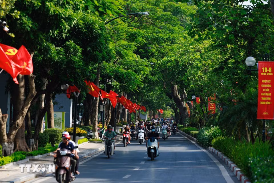 Cờ Đảng, cờ Tổ quốc nối dài giữa những hàng cây, hòa cùng dòng người qua lại, khiến không khí ngày Tết Độc lập hiện diện ngay trong nhịp sống thường nhật của Hà Nội. (Ảnh: Phạm Tuấn Anh/TTXVN)