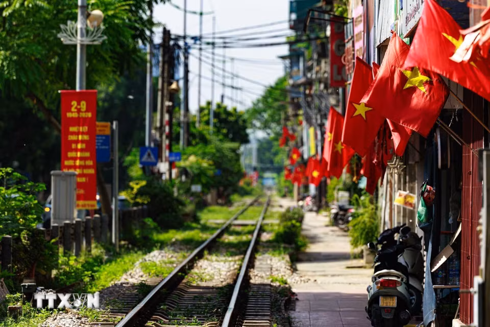 Dọc tuyến đường sắt đi qua khu dân cư, những lá cờ Tổ quốc nối tiếp nhau trước mỗi ngôi nhà, cho thấy không khí Quốc khánh không chỉ hiện diện tại những quảng trường, đại lộ mà còn đi vào từng góc nhỏ của thành phố. (Ảnh: Phạm Tuấn Anh/TTXVN)