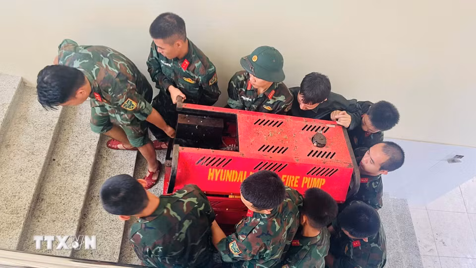 Bộ đội hỗ trợ di dời tài sản của Trường Mầm non Xuân Mai (xã Xuân Mai, Hà Nội) lên cao. (Ảnh: TTXVN phát)
