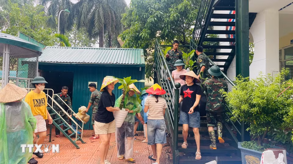 Người dân hỗ trợ trường Mầm non Xuân Mai (xã Xuân Mai, Hà Nội) di dời tài sản, tránh ngập nước. (Ảnh: TTXVN phát)