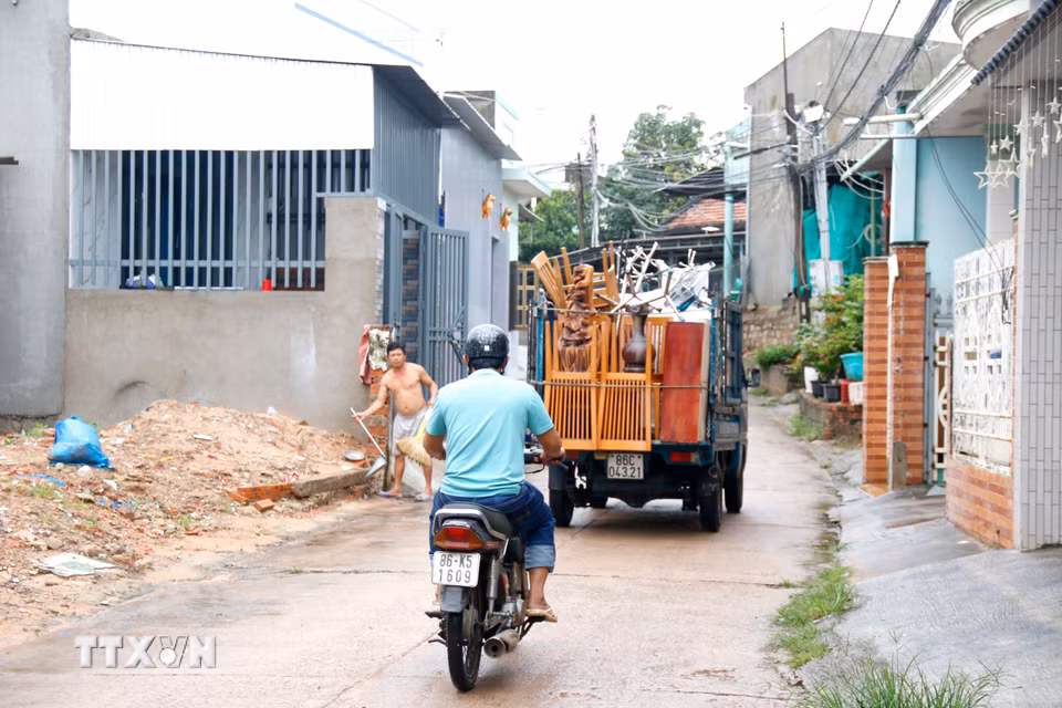 Các hộ dân ven sông Cái (phường Hàm Thắng, tỉnh Lâm Đồng) di dời tài sản đến nơi khác để tránh lũ. (Ảnh: Nguyễn Thanh/TTXVN)