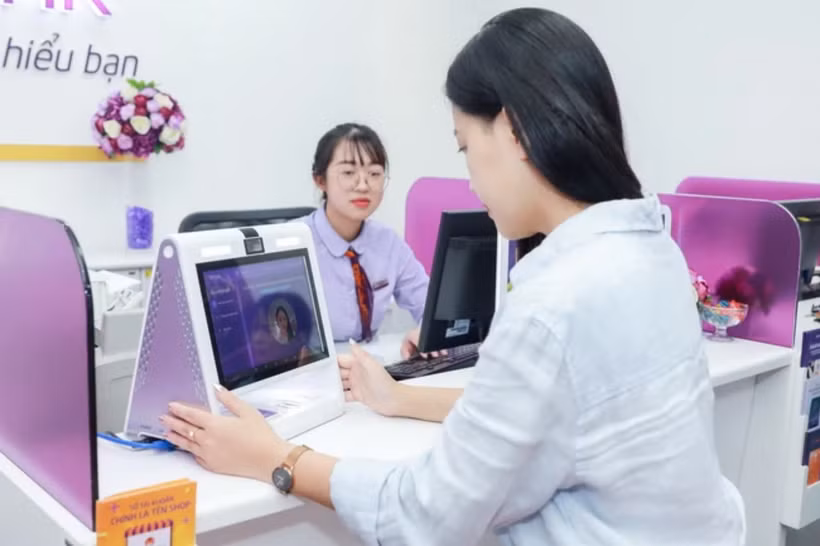 Khách hàng cập nhập khuôn mặt tại phòng giao dịch. (Ảnh: Vietnam+)