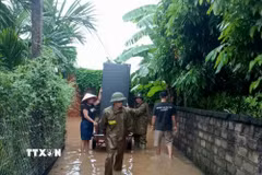 Lực lượng chức năng hỗ trợ người dân di chuyển tài sản đến nơi an toàn. (Ảnh: Đồng Thúy/TTXVN)
