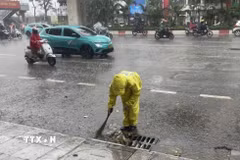 Công nhân Công ty Trách nhiệm hữu hạn Một thành viên Thoát nước Hà Nội vớt rác để tiêu thoát nước nhanh. (Ảnh: Nguyễn Thắng/TTXVN)