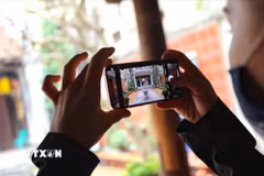 Du khách lưu lại những hình ảnh đẹp khi ghé thăm một ngôi đình ở Hà Nội. (Ảnh: Thanh Tùng/TTXVN)