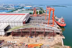 Thử tải tổ hợp kết cấu vòm chính và hệ khung đỡ nặng 3.400 tấn của cầu đi bộ qua sông Sài Gòn tại nhà máy. (Ảnh: TTXVN phát)
