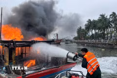 Lực lượng chức năng nỗ lực khống chế tàu cá bị cháy. (Ảnh: TTXVN phát)