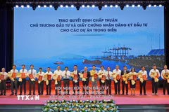 Lãnh đạo Ủy ban Nhân dân tỉnh Cà Mau trao quyết định chấp thuận chủ trương đầu tư và giấy chứng nhận đăng ký đầu tư cho các dự án trọng điểm. (Ảnh: Huỳnh Anh/TTXVN)
