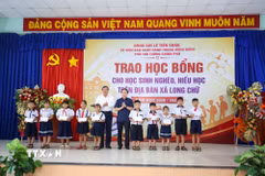 Các học sinh nghèo, hiếu học tại xã Long Chữ, tỉnh Tây Ninh nhận học bổng từ Phó Thủ tướng Chính phủ Lê Tiến Châu (phải) và Chủ tịch UBND tỉnh Tây Ninh Lê Văn Hẳn (trái). (Ảnh: Giang Phương/TTXVN)