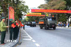 Cựu chiến binh và nhân dân chào đón đoàn xe chở hài cốt 93 liệt sỹ di chuyển qua khu vực Quảng trường 26/3 phường Hà Giang 1, tỉnh Tuyên Quang. (Ảnh: Minh Tâm/TTXVN)