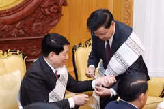 Tổng Bí thư, Chủ tịch nước Lào Thongloun Sisoulith buộc chỉ cho Chủ tịch nước Lương Cường. (Ảnh: Lâm Khánh/TTXVN)