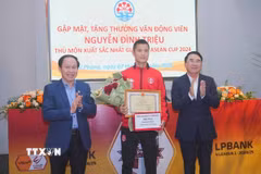 Ông Lê Tiến Châu, Bí thư Thành ủy Hải Phòng tặng thưởng, động viên thủ môn Nguyễn Đình Triệu. (Ảnh: Hoàng Ngọc/TTXVN)