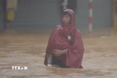 Người dân di chuyển khó khăn tại khu vực nước sâu. (Ảnh: Văn Dũng/TTXVN)