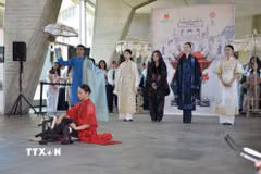 Ca sỹ Thanh Lam (áo đen đứng giữa) hát nền trong phần trình diễn áo dài của nhà thiết kế Minh Hạnh tại sự kiện. (Ảnh: Hữu Chiến/TTXVN)