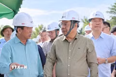 Phó Thủ tướng Thường trực Phạm Gia Túc nghe đại diện nhà thầu báo cáo tiến độ thi công tại công trường. (Ảnh: TTXVN phát)