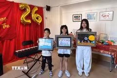 Em François Phạm, 8 tuổi (bên trái), cùng các thí sinh giới thiệu những tác phẩm tham dự cuộc thi vẽ tranh về Mặt Trăng. Bức tranh của François Phạm, khắc họa con tàu Việt Nam tuần tra trong đêm trăng rằm, đã giành giải Nhất nhờ thông điệp hướng về Trường Sa và những người lính đang ngày đêm gìn giữ biển, đảo quê hương. (Ảnh: Trần Đức Hùng/TTXVN)