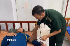 Quân y Đồn Biên phòng Sông Đốc (Cà Mau) chăm sóc sức khỏe cho các thuyền viên gặp nạn. (Ảnh: TTXVN phát)