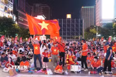 Người hâm mộ với cờ đỏ sao vàng, trống và kèn tập trung tại phố đi bộ Nguyễn Huệ, sẵn sàng tiếp lửa cho đội tuyển Việt Nam trong trận chung kết lượt đi ASEAN Hyundai Cup 2026 gặp Thái Lan. (Ảnh: Trung Tuyến/TTXVN)