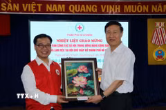 Ông Nguyễn Minh Nhựt, Chủ tịch Hội Chữ thập Đỏ Thành phố Hồ Chí Minh tặng quà lưu niệm ông Zhao Shi Tang, Phó Trưởng ban Ban Công tác xã hội Trung ương Đảng Cộng sản Trung Quốc. (Ảnh: Thanh Vũ/TTXVN)