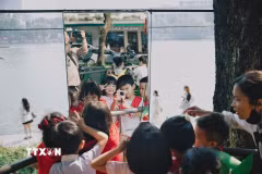Các em nhỏ vui đùa với chong chóng. (Ảnh: Phạm Tuấn Anh/TTXVN)