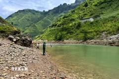 Lực lượng chức năng mở rộng phạm vi tìm kiếm dọc sông Nho Quế, xã Sơn Vĩ, tỉnh Tuyên Quang. (Ảnh: TTXVN phát)