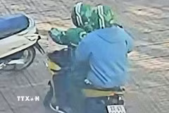 Các đối tượng dùng súng cướp ngân hàng. (Ảnh chụp màn hình camera. TTXVN phát)