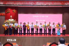 Bí thư Thành ủy Hà Nội Trần Đức Thắng và lãnh đạo Thành phố trao các quyết định và tặng hoa chúc mừng các đồng chí nhận nhiệm vụ mới. (Ảnh: Văn Điệp/TTXVN)
