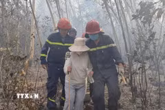 Đưa người dân bị kẹt trên núi xuống an toàn. (Ảnh: TTXVN phát)
