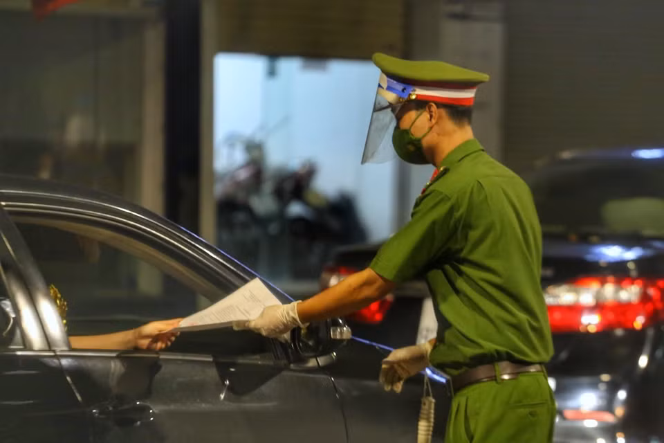 Tổ công tác của công an quận Hoàn Kiếm kiểm tra giấy đi đường của người tham gia giao thông. (Ảnh: Tuấn Đức/TTXVN)