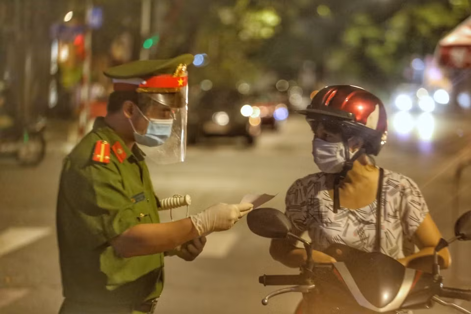 Lực lượng chức năng kiểm tra giấy tờ tại chốt kiểm soát phố Huế. (Ảnh: Tuấn Đức/TTXVN)