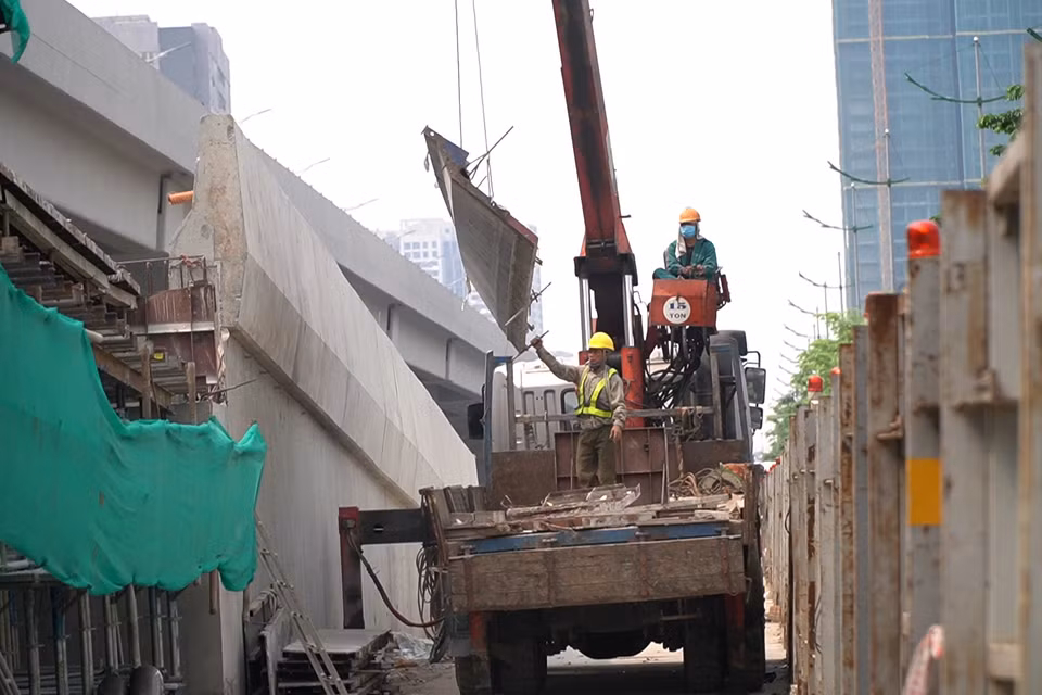 Công nhân lắp ráp giàn giáo nhánh Ram lên/xuống khu vực Hoàng Quốc Việt. (Ảnh: Văn Hào/Vietnam+)