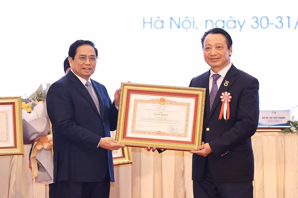 Thủ tướng Phạm Minh trao Bằng khen cho ông Nguyễn Quang Vinh, Tổng Thư ký VCCI. (Ảnh: Dương Giang/TTXVN)