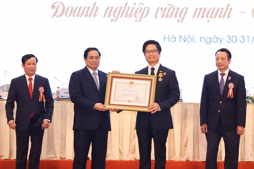 Thủ tướng Phạm Minh trao Huân chương Lao động hạng Nhì cho ông Vũ Tiến Lộc, nguyên Chủ tịch VCCI. (Ảnh: Dương Giang/TTXVN)