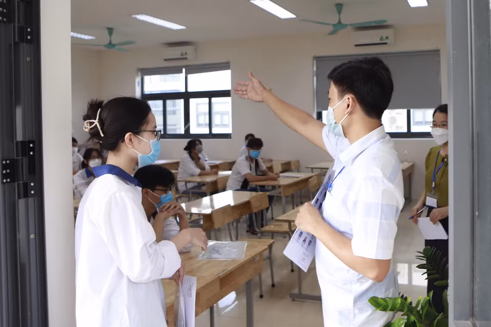  Hướng dẫn thí sinh vào phòng thi tại điểm thi Trường THPT chuyên Vĩnh Phúc, thành phố Vĩnh Yên, tỉnh Vĩnh Phúc. (Ảnh: Hoàng Hùng/TTXVN)