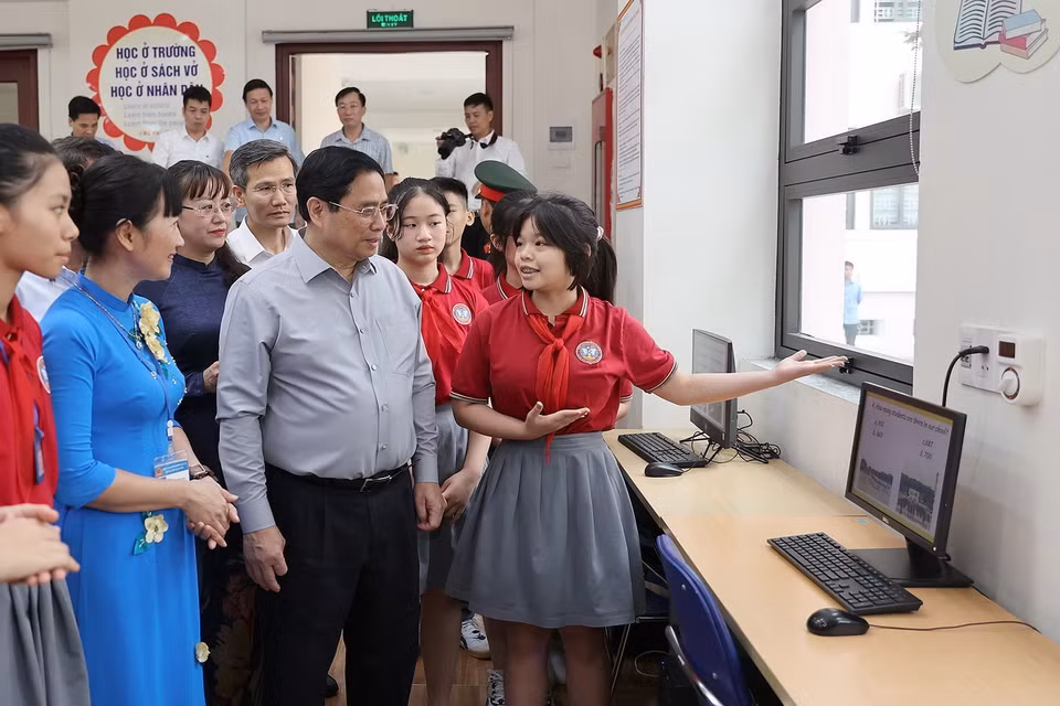 Thủ tướng Phạm Minh Chính nghe học sinh giới thiệu về cơ sở vật chất cụm liên trường học thành phố Lào Cai. (Ảnh: Dương Giang/TTXVN)