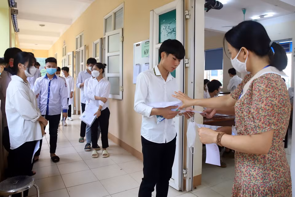  Cán bộ coi thi tại Hội đồng coi thi THPT Thanh Thủy, tỉnh Phú Thọ gọi thí sinh vào phòng thi. (Ảnh: Trung Kiên/TTXVN)