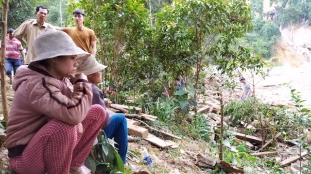 Người dân trong khu sạt lở Trà Leng ngồi chờ thông tin từ lực lượng tìm kiếm. (Ảnh: Trần Lê Lâm/TTXVN)