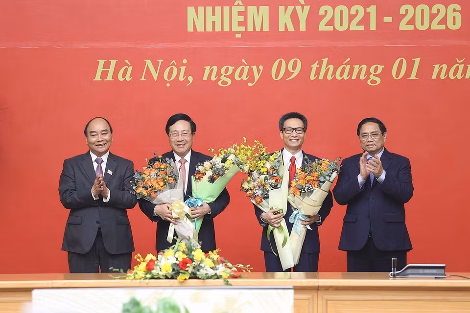 Chủ tịch nước Nguyễn Xuân Phúc và Thủ tướng Phạm Minh Chính tặng hoa chia tay ông Phạm Bình Minh và ông Vũ Đức Đam. (Ảnh: Dương Giang/TTXVN)
