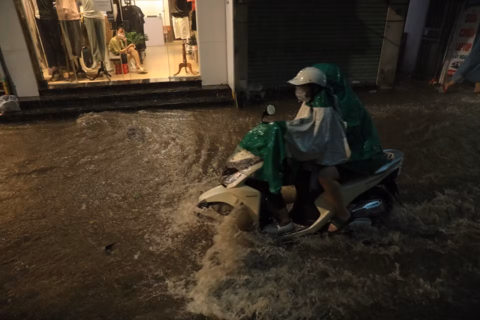 Phố Khương Hạ, quận Thanh Xuân ngập khiến nhiều người đi lại khó khăn. (Ảnh: Tuấn Anh/TTXVN)